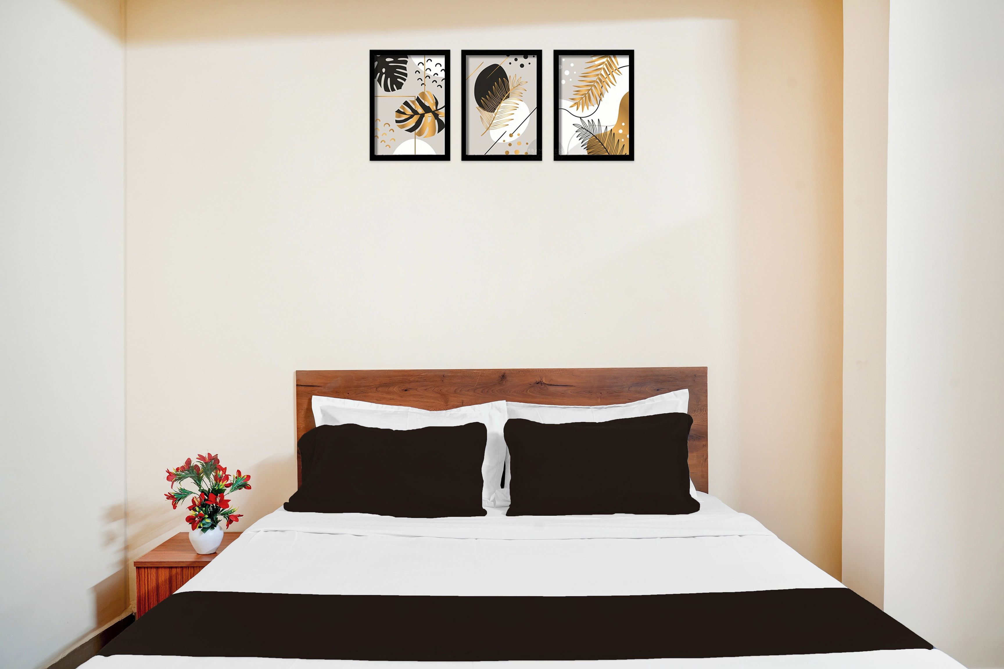 Una habitació d'hotel amb un llit, una taula de nit i un quadre penjat a la paret.