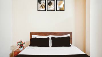 Una habitación de hotel con una cama, una mesita de noche y un marco de fotos colgado en la pared.