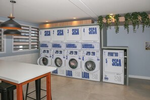 Ett tvättrum med fem tvättmaskiner, var och en försedd med ett nummer och instruktioner.