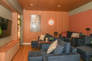 A modern living room with a flat-screen TV, multiple sofas, and a coffee table. - Premium studio near Faria Lima (São Paulo)