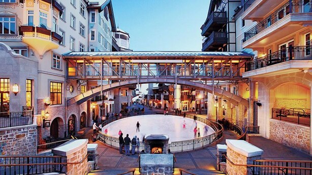 Ein Innenhof mit einer zentralen Eisbahn, Steinmauern und einer Feuerstelle.