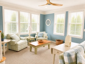 A room with a ceiling fan, a sofa, a coffee table, and a window with blinds. - Sunset Island 2 Shore Point Drive (Ocean City)