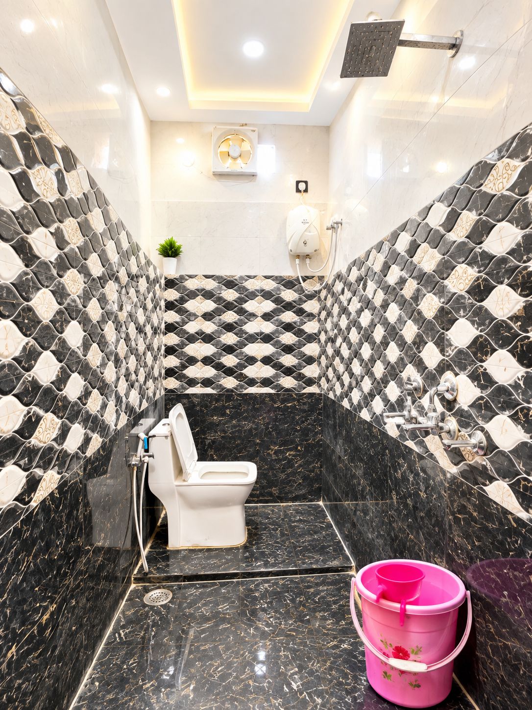 Een badkamer met een toilet, een douche en een roze emmer op de vloer.