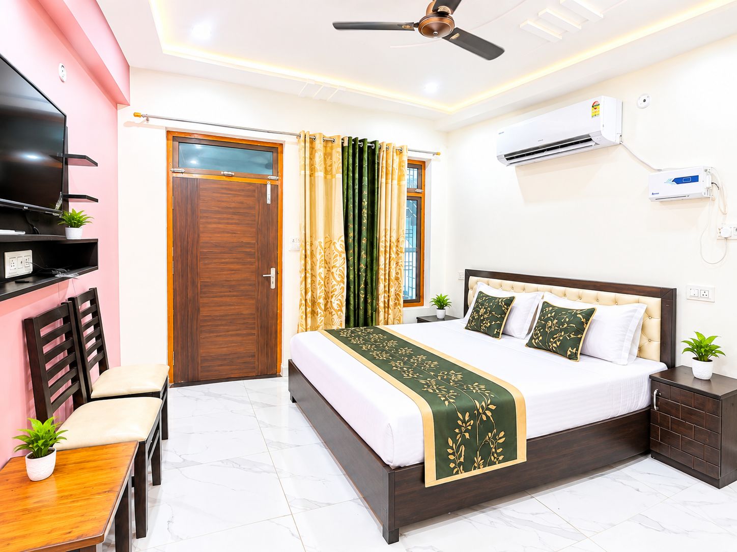Un dormitorio con cama, televisor, ventilador de techo, equipo de aire acondicionado y ventana con cortinas.