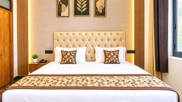 Una habitación de hotel con una cama grande, un cabecero de madera, suelo de mármol y cuadros en la pared.