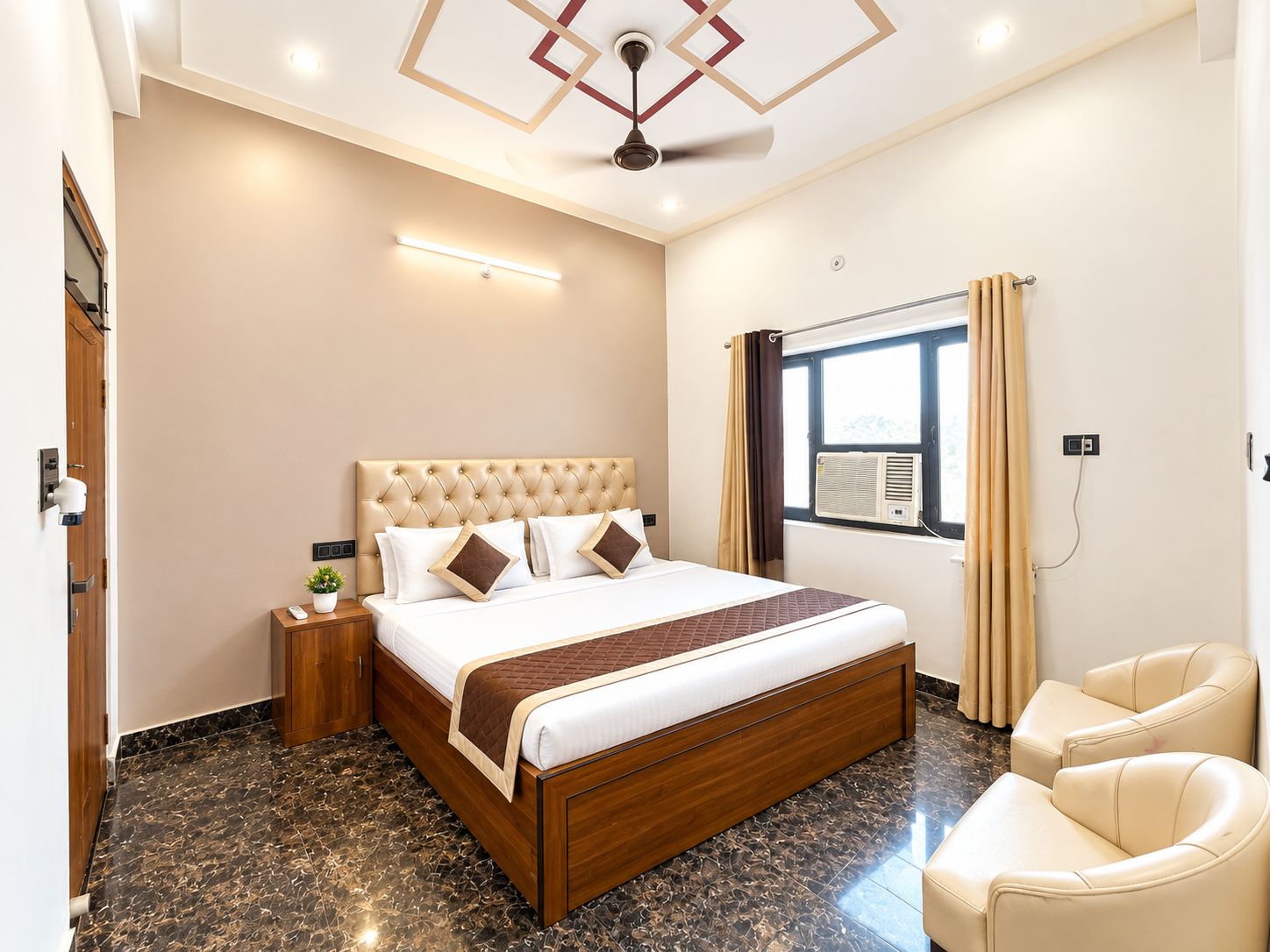 A hotel room with a bed, bedside table, lamp, and a window with curtains.