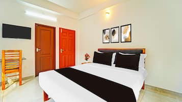 Un dormitorio con cama, televisor montado en la pared y dos puertas.