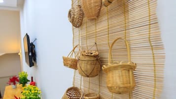 A wall with woven baskets and a table with potted plants.