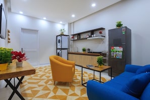 Une cuisine moderne équipée d’un réfrigérateur, d’un lave-linge et d’un coin repas avec une table et des chaises.