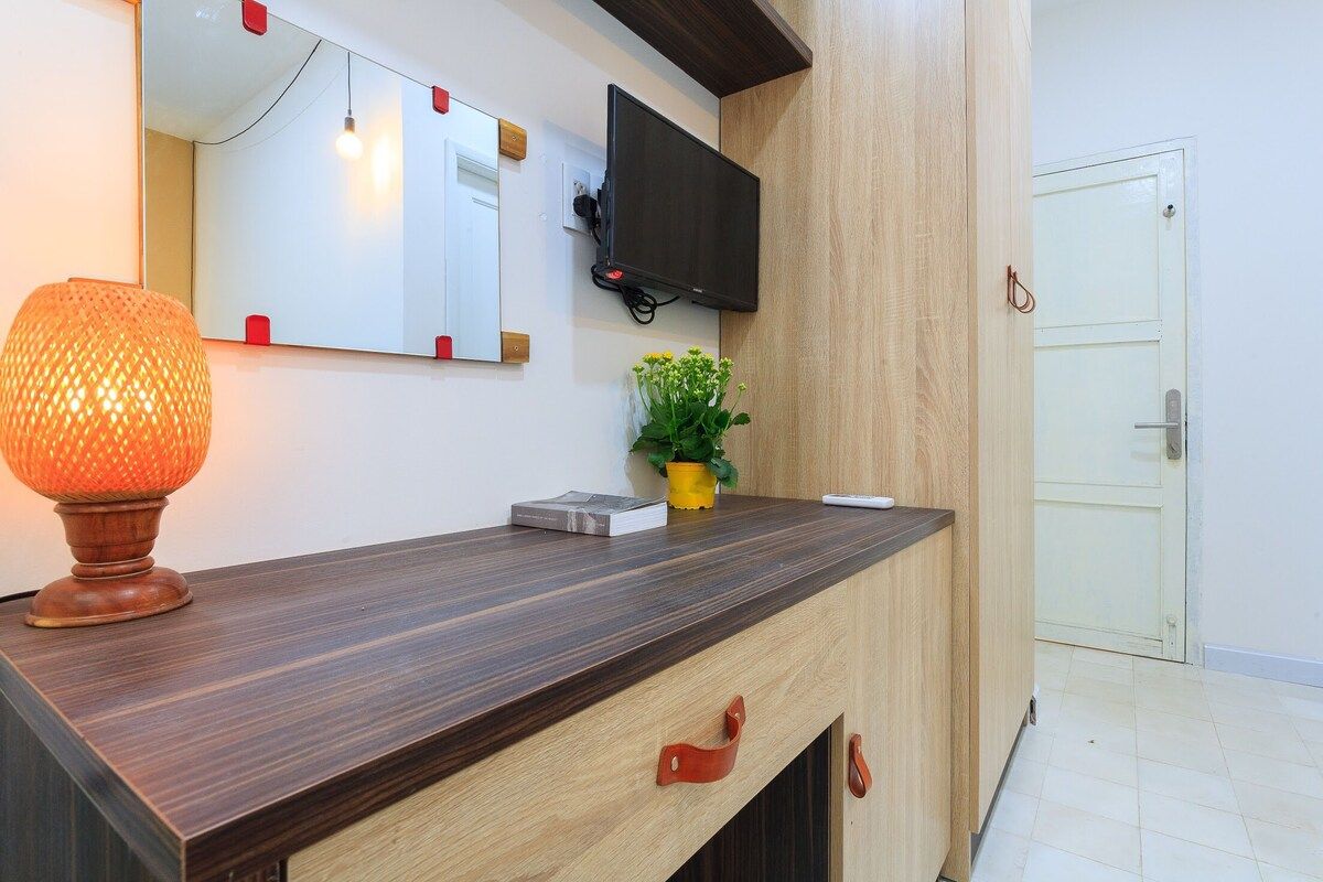 A modern reception desk with a flat-screen TV, a decorative lamp, and a small potted plant.