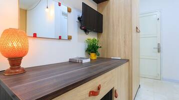 A modern reception desk with a flat-screen TV, a decorative lamp, and a small potted plant.