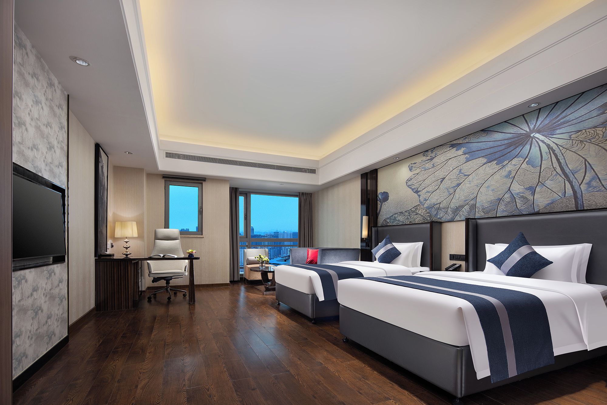 A hotel room with two beds, a desk, a chair, a TV, and a large window with a city view.