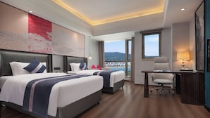Ein Hotelzimmer mit zwei Betten, einem Schreibtisch und einem Stuhl.