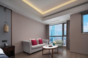 A modern hotel room with a sofa, a round coffee table, and a city view through large windows. - Jiaruide Hotel IFS Changsha (Changsha)