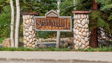 A wooden sign with the text 'SAW MILL INN' surrounded by a stone wall.
