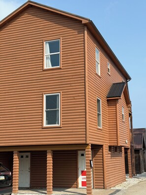 A two-story log cabin with a garage, a door with a 'laundering' sign, and a clear sky. - 3-bedroom cabin centrally located between Geneva on the lake  & Ashtabula Harbor (Ashtabula)