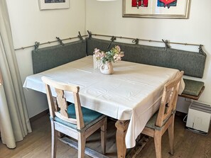 Ein Essbereich mit einem Tisch für zwei Personen, einer Bank und einer an der Wand befestigten Bar.