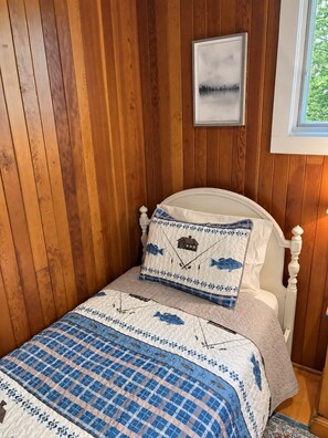 A bed with a checkered bedspread and two pillows with a fishing theme. - The Lakefront Muskoka Detour (Gravenhurst)
