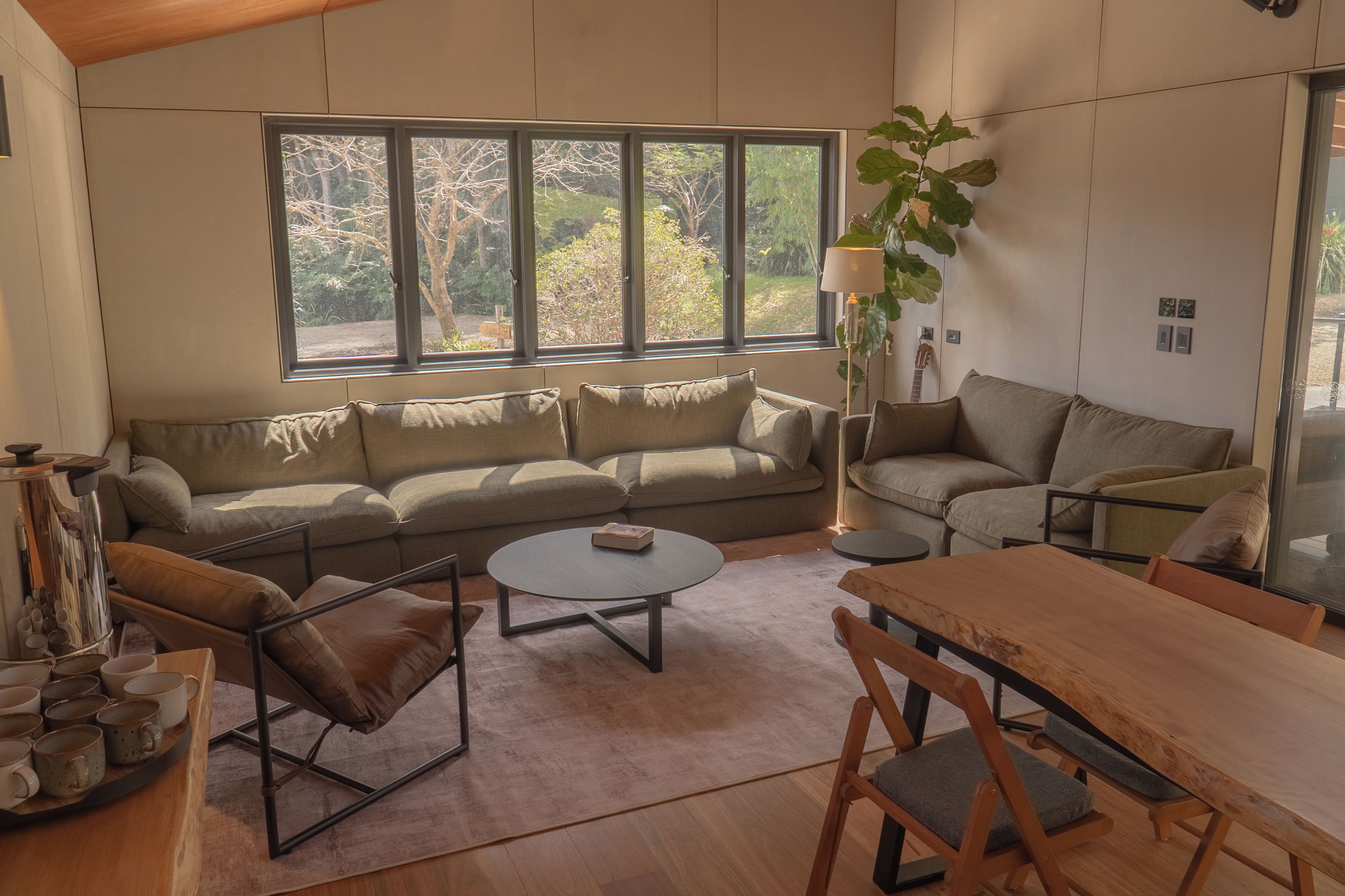 A modern living room with a sofa, a coffee table, and a dining table.