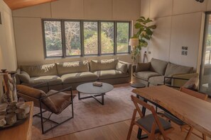 A modern living room with a sofa, a coffee table, and a dining table.