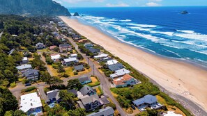 A coastal residential area with houses, a beach, and ocean waves. - The Grey Piper by Avantstay Ocean Views + Fire Pit + BBQ Walk to Beach (Arch Cape)