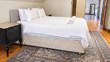 A bedroom with a bed, nightstand, and a patterned rug.