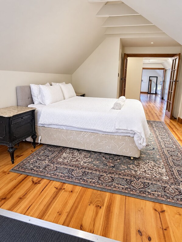 A bedroom with a bed, nightstand, and a patterned rug.