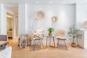 A modern living room with a sofa, two chairs, a coffee table, and decorative wall art. - GuestReady - Marbella Park (Marbella)