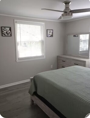 A bedroom with a bed, a ceiling fan, a window with blinds, and a dresser. - Cozy home in Ardmore Winston-Salem pet friendly, close to hospital & University (Winston-Salem)