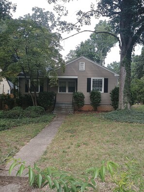 A single-story house with a front porch, a small front yard, and a pathway leading to the entrance. - Cozy home in Ardmore Winston-Salem pet friendly, close to hospital & University (Winston-Salem)