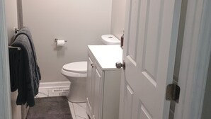 A bathroom with a toilet, sink, and a towel rack with towels. - Cozy home in Ardmore Winston-Salem pet friendly, close to hospital & University (Winston-Salem)