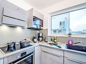 A modern kitchen with a built-in oven, microwave, and coffee maker. - Apartment Ahoi by Interhome (Hasselberg)