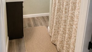 Un bagno con lavandino, specchio, finestra e tenda per la doccia.