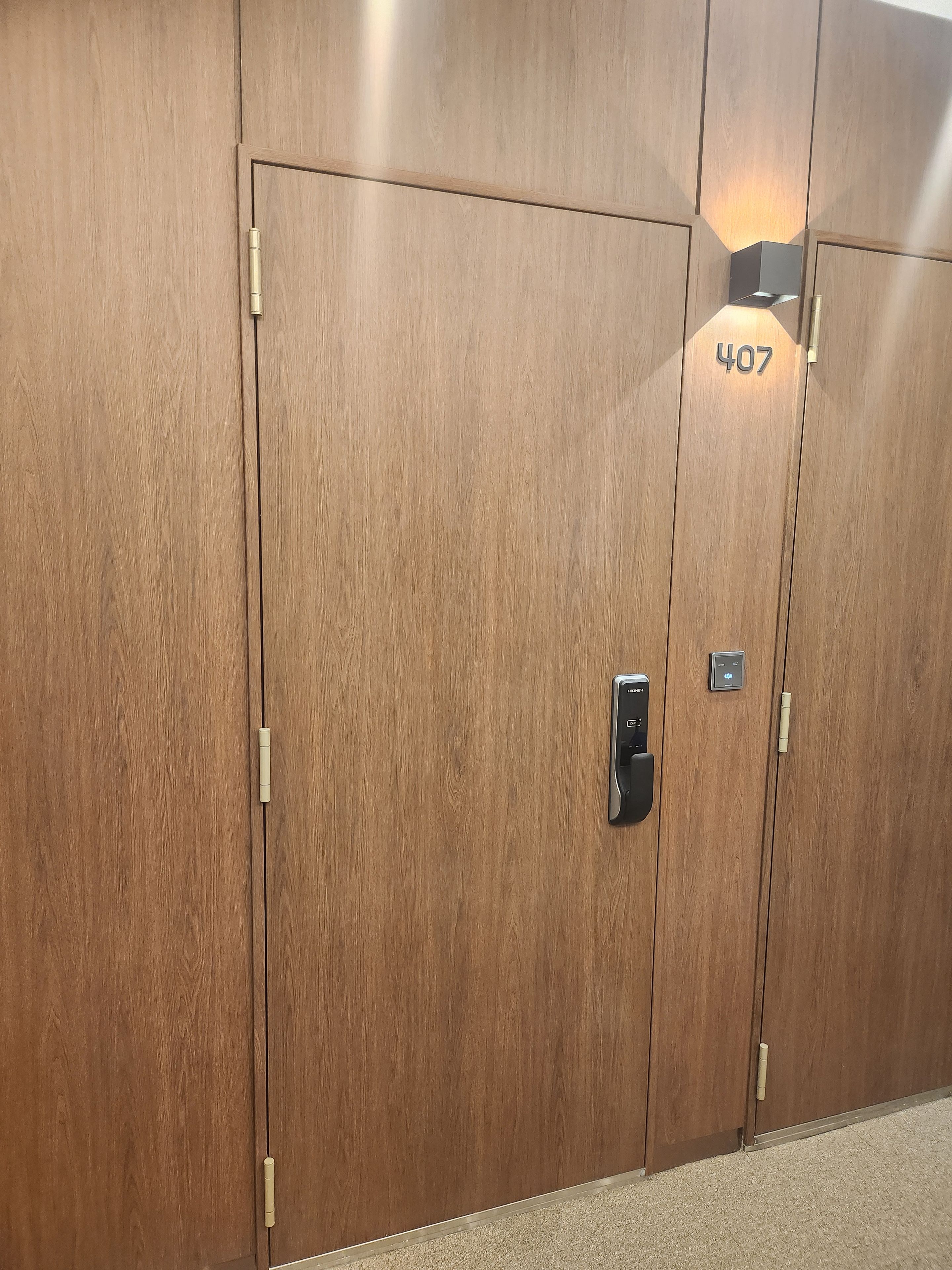 Een paar houten dubbele deuren met het nummer '407' en een kaartlezer.