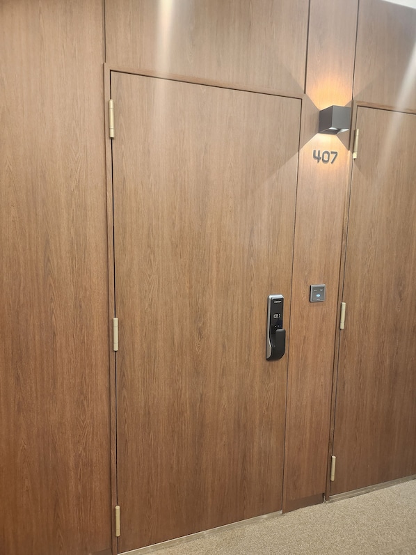 A set of wooden double doors with a number '407' and a keycard reader. - THE DH STAY (Seoul)