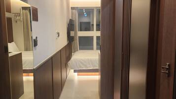 Una habitación de hotel moderna con cama, armario y espejo.