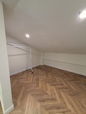 A room with a wooden herringbone floor, white walls, and a metal ladder. - Cozy 1-bedroom apartment in northside Bucharest with AC and terrace (București)