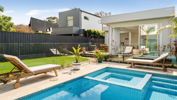 A modern outdoor pool area with two lounge chairs, a small garden, and a glass-enclosed patio. - Mira Sol, Richmond Hosted by L'Abode Accommodation (Richmond)