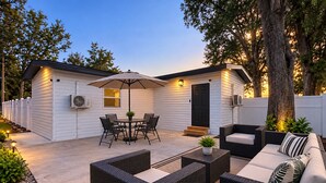 A patio area with outdoor furniture, a table with chairs, and a covered seating area. - Stadium Nest /king Bed/ pet friendly (Tampa)