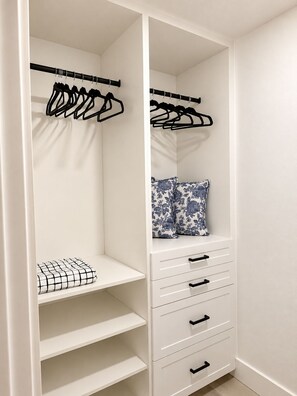 A white closet with hanging space, shelves, and drawers.