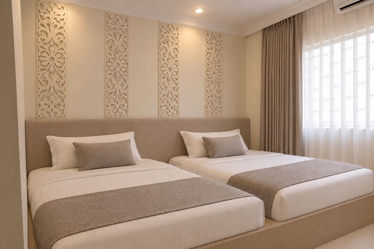 A hotel room with two beds, a decorative wall panel, and a window with curtains.