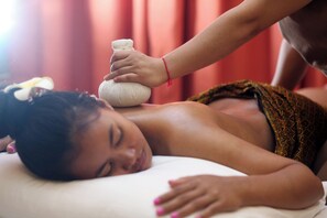 A person receiving a massage with a stone on their back. - Central Boutique (Siem Reap)