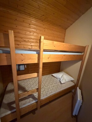 A bunk bed with a wooden frame and a mattress with a patterned cover. - LE CHAMOIS No. 8 - A 6-person chalet surrounded by nature, lakes, and waterfalls in the Jura (Uxelles)