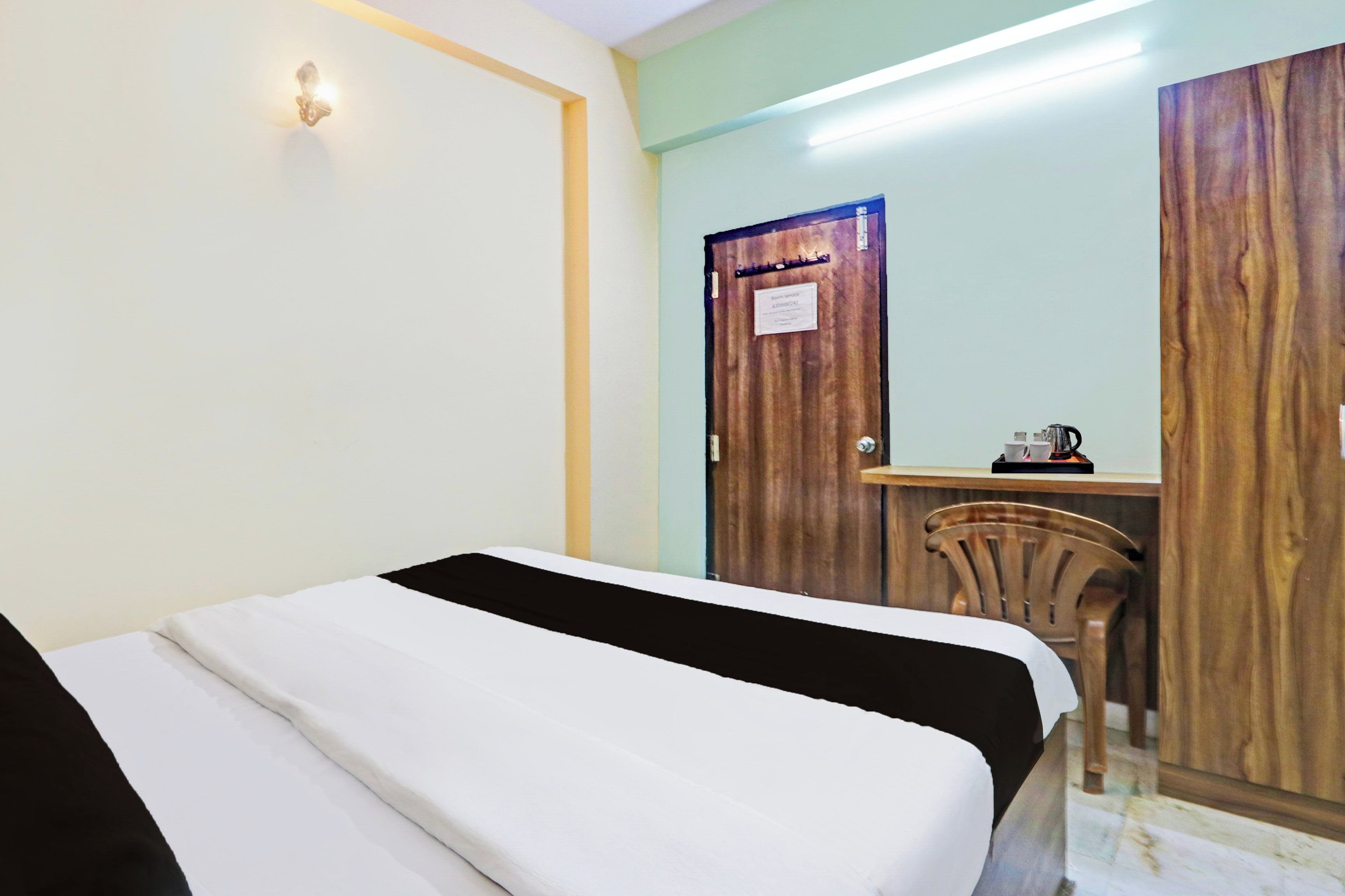 A hotel room with a bed, a desk, and a chair.
