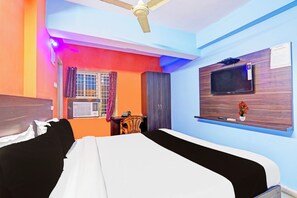 A hotel room with a bed, a desk, a TV, and a window with curtains. - Hotel O Karimnagar (Karimnagar)