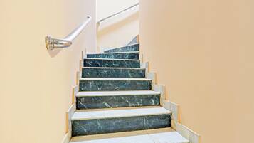 A staircase with marble steps and a metal handrail.