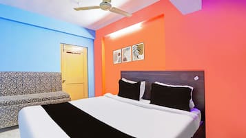 Una habitación con cama, sofá, ventilador de techo y una puerta.