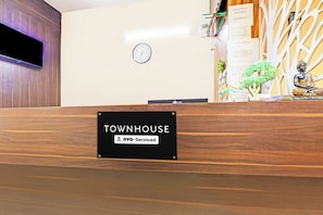 A reception desk with a sign reading 'TOWNHOUSE' and 'OYO-Serviced'.