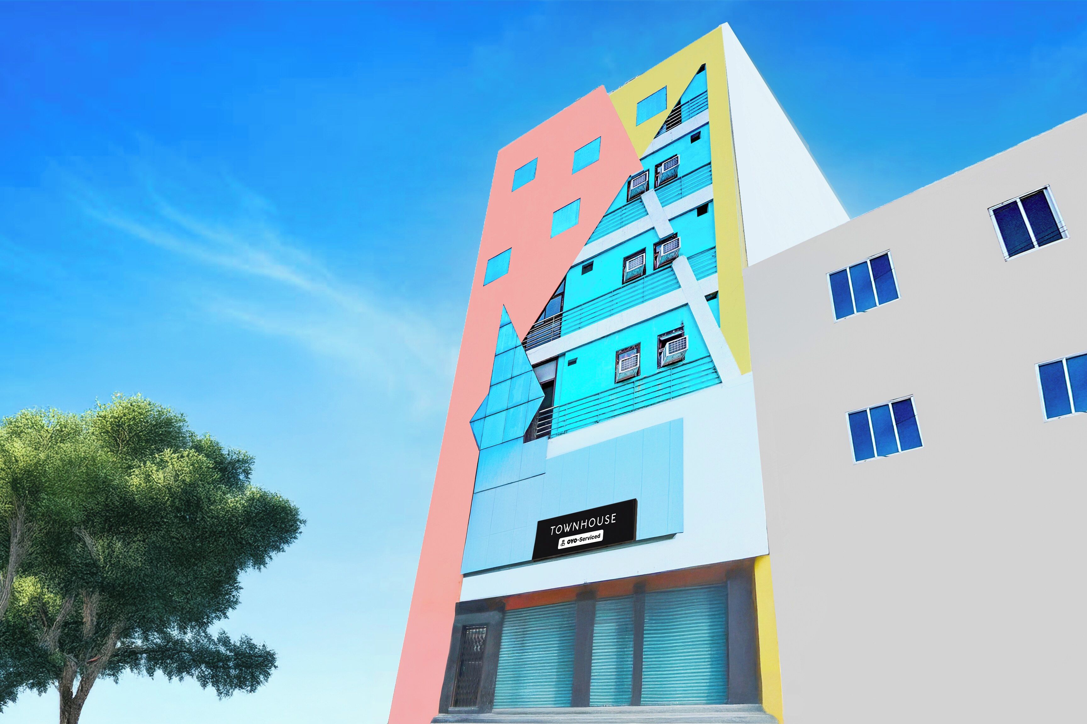 A multi-story building with a sign indicating it is a serviced townhouse.