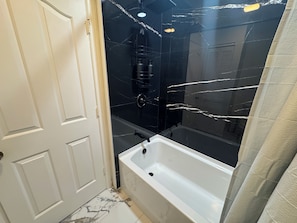 A bathroom with a bathtub, a shower, and a toilet. - Tranquil 2-bedroom townhome with AC in charming Clewiston (Clewiston)